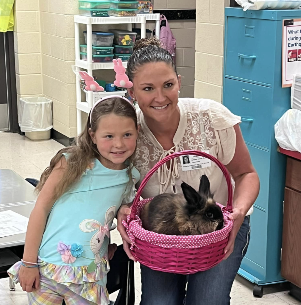 teacher and student holding bunny in basket